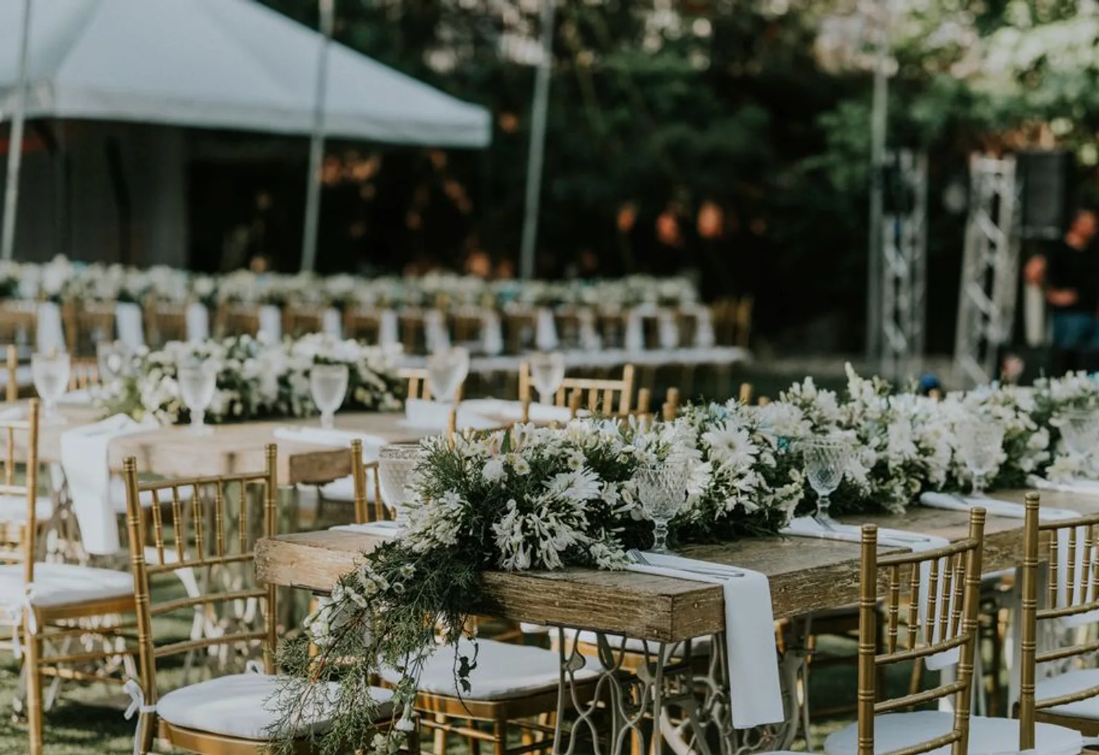 Rows of chairs and florals set for a ceremony on the grass