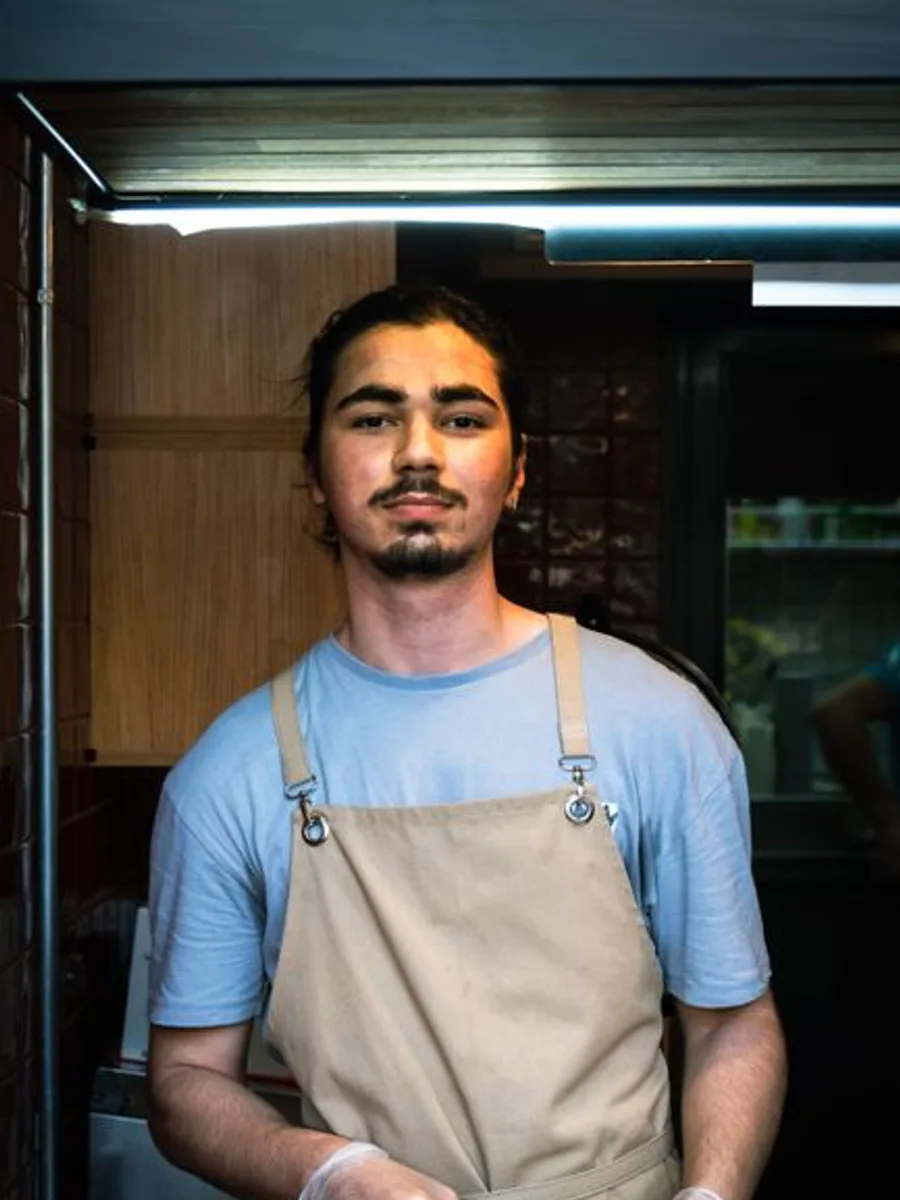 Owen, who runs breakfast and dinner service, in an apron