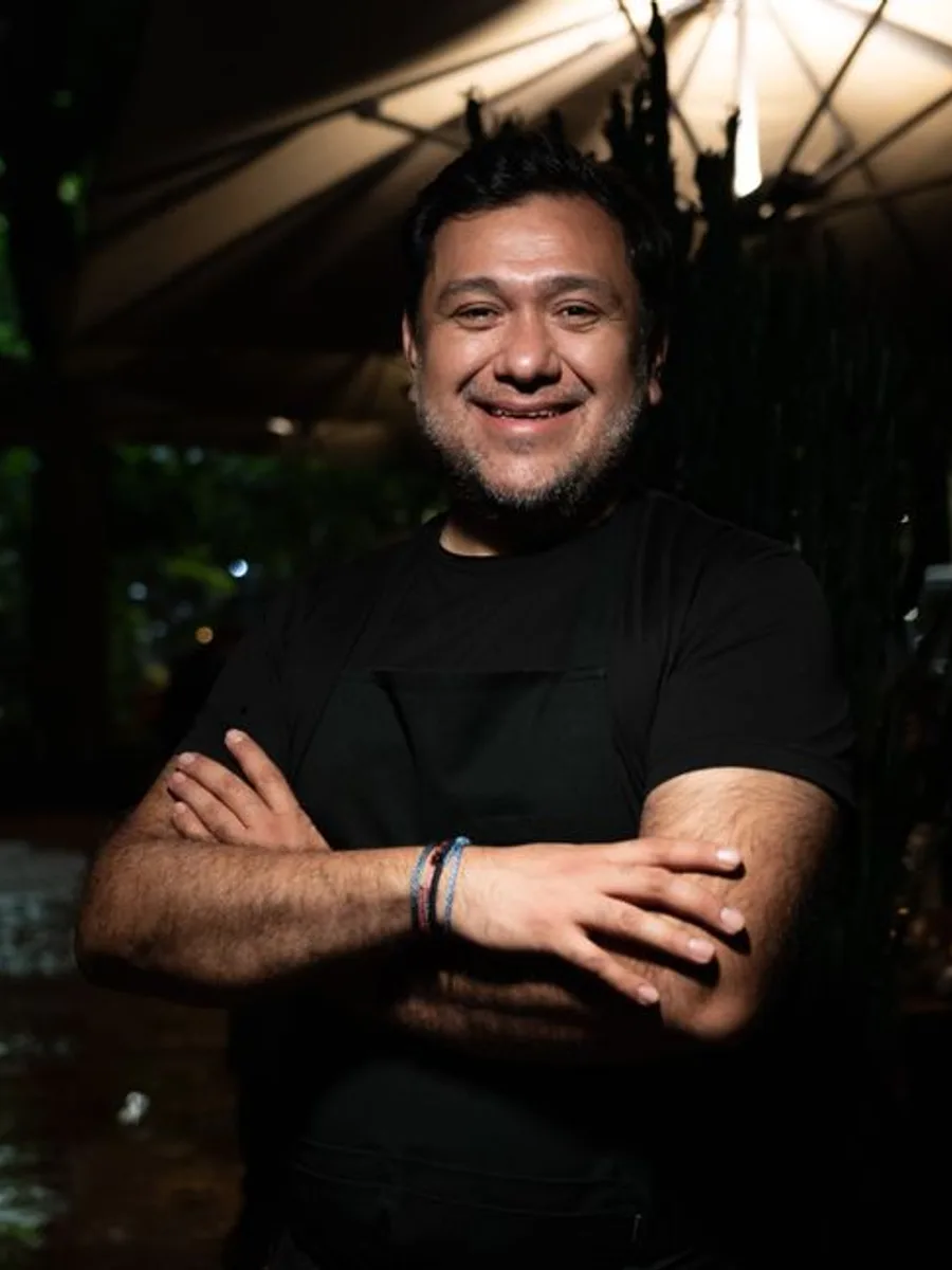 Peter, innkeeper and cook, arms folded in the kitchen